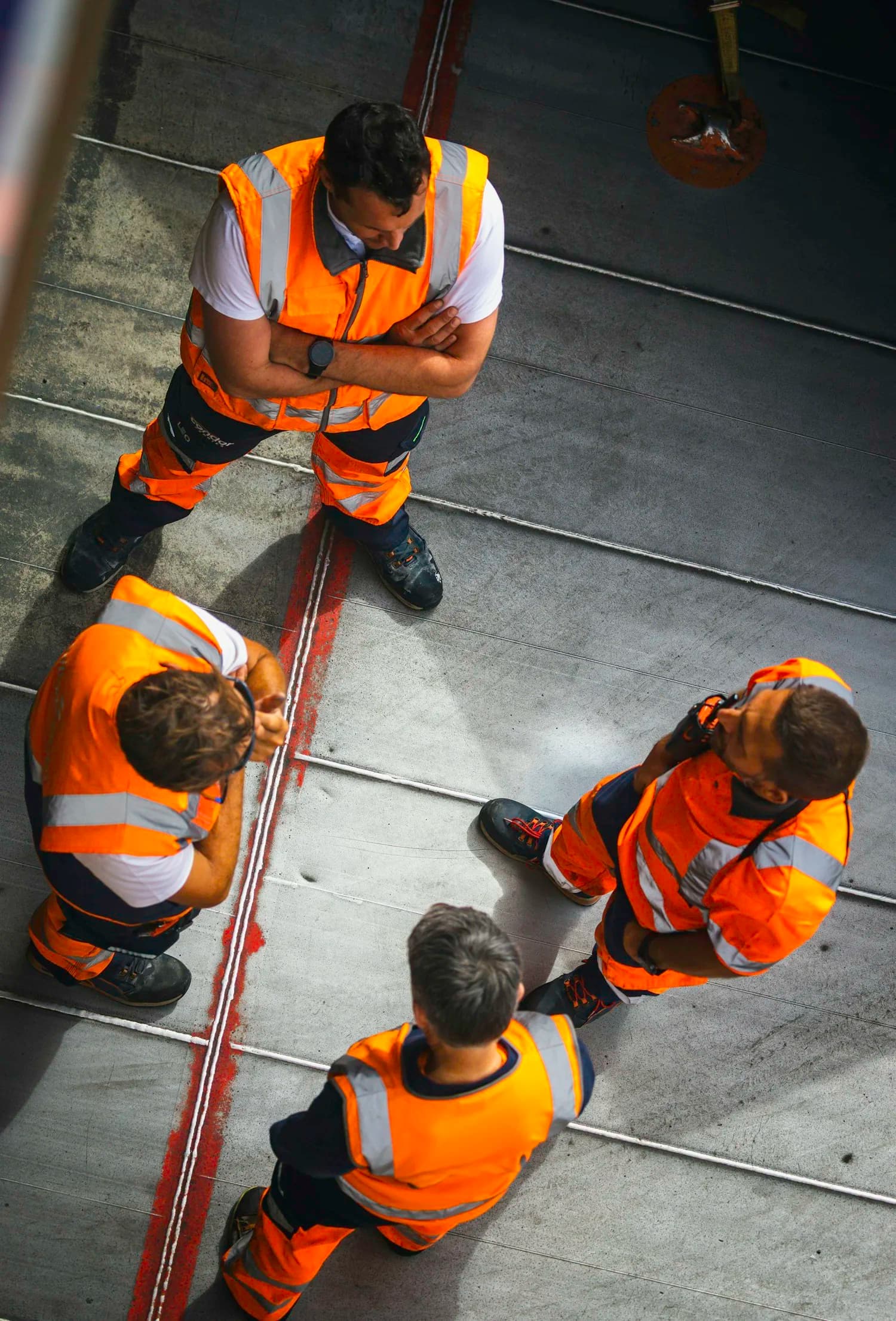 Site crew in high-visibility workwear viewed from above